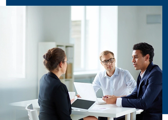 Three people sitting at a table talking to each other.